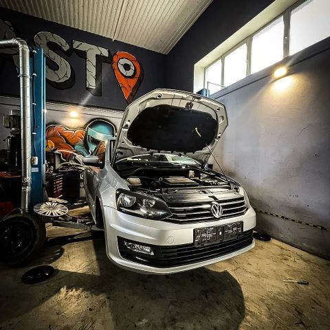 Volkswagen Polo с открытым капотом в боксе СТО Дасто
